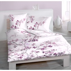 Linge de lit SAKURA sur un lit, housse de couette et taies en satin de coton