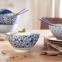 Bol donburi japonais à arabesques fleuries garni de riz, sur une table en bois