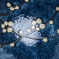 Détail des fleurs de cerisier blanches sur l’émail bleu nuit