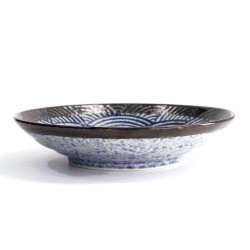 Assiette creuse ARASHI de profil, dessous moucheté bleu et blanc, petit pied