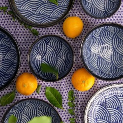 Bols et assiettes de la collection ARASHI sur une nappe japonaise, avec des oranges