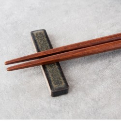 Baguettes en bois posées sur le repose-baguettes TILE TALE, émail anthracite aux reflets bronze